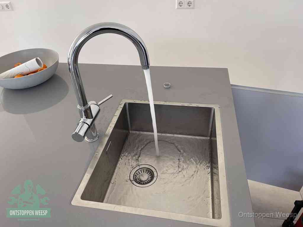 Een vrij doorstromende rvs spoelbak waar het water moeiteloos wegloopt, het resultaat van slim onderhoud dat geld bespaart in Weesp