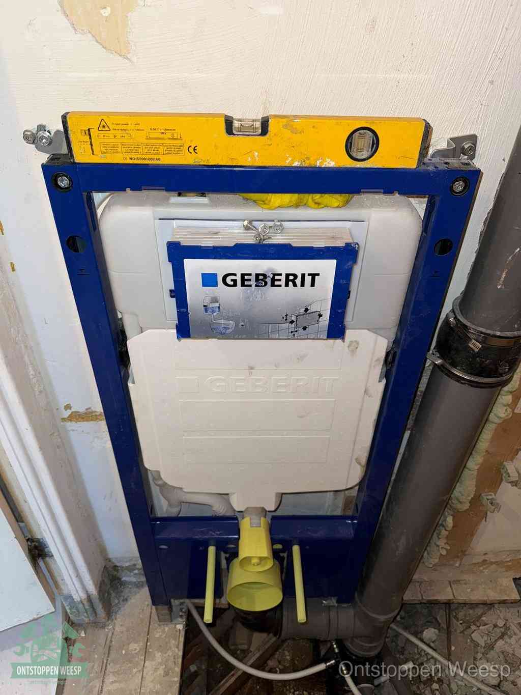 Een Geberit inbouwreservoir met frame voor een hangtoilet tegen de wand, met de afvoerbocht naar de vloer, kenmerkend voor een verstopt hangtoilet in Weesp