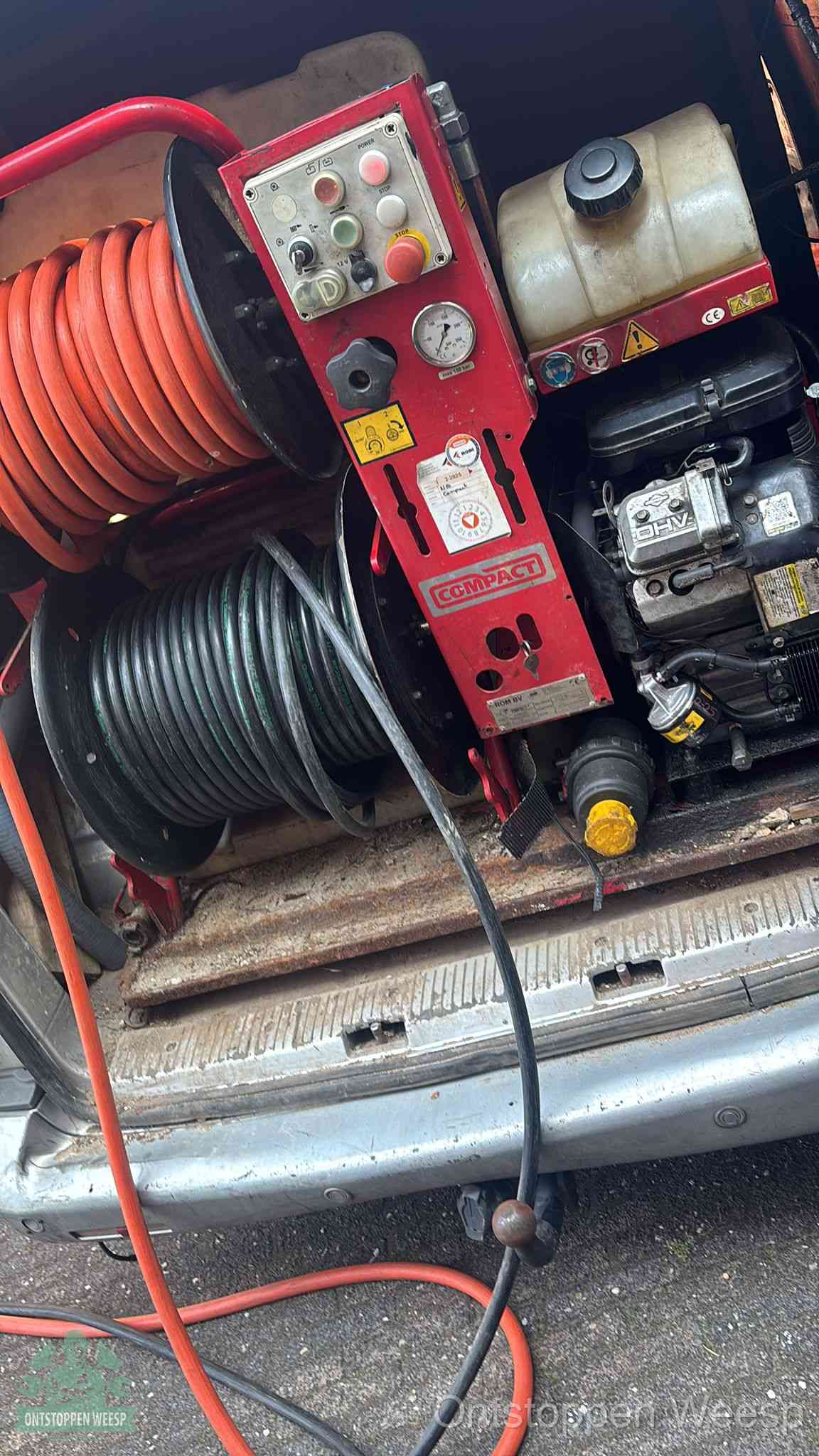 Een rood hogedruk-rioolreinigingstoestel in de laadbak van de bedrijfsbus, apparatuur voor een hardnekkige afvoerverstopping in Weesp
