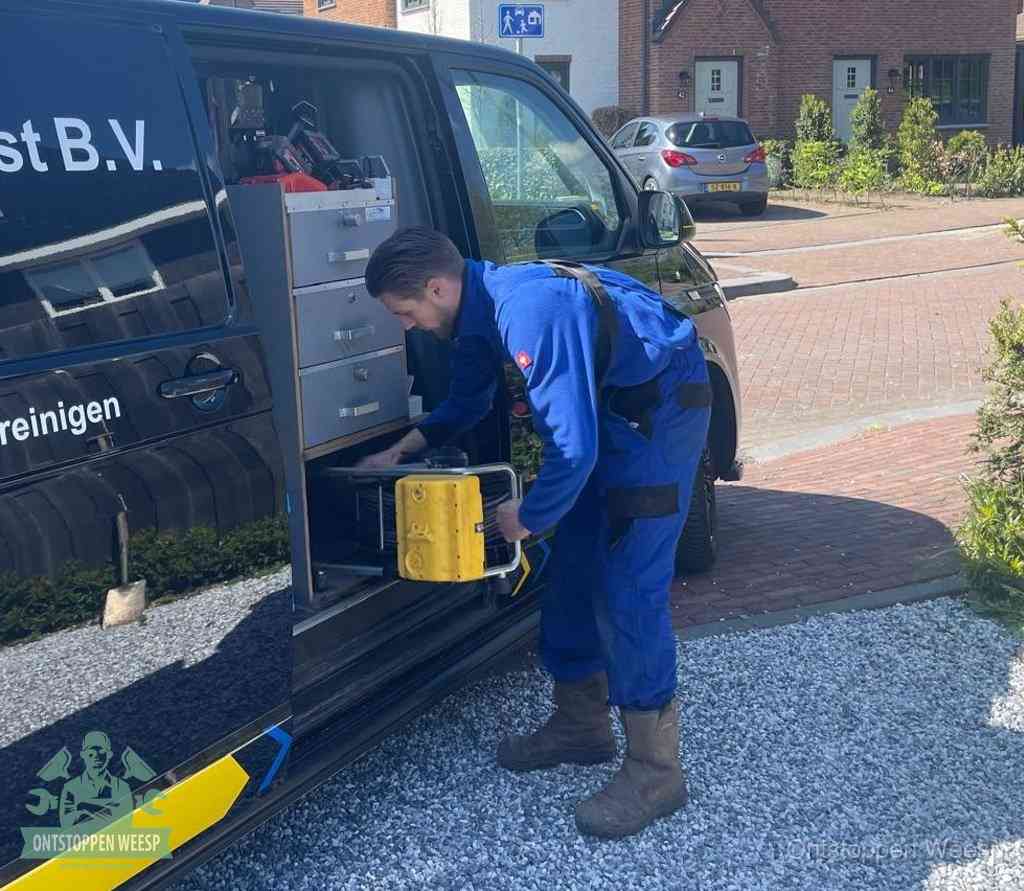 Een monteur pakt apparatuur uit de bedrijfsbus voor service aan huis, het moment om een professional in te schakelen in Weesp