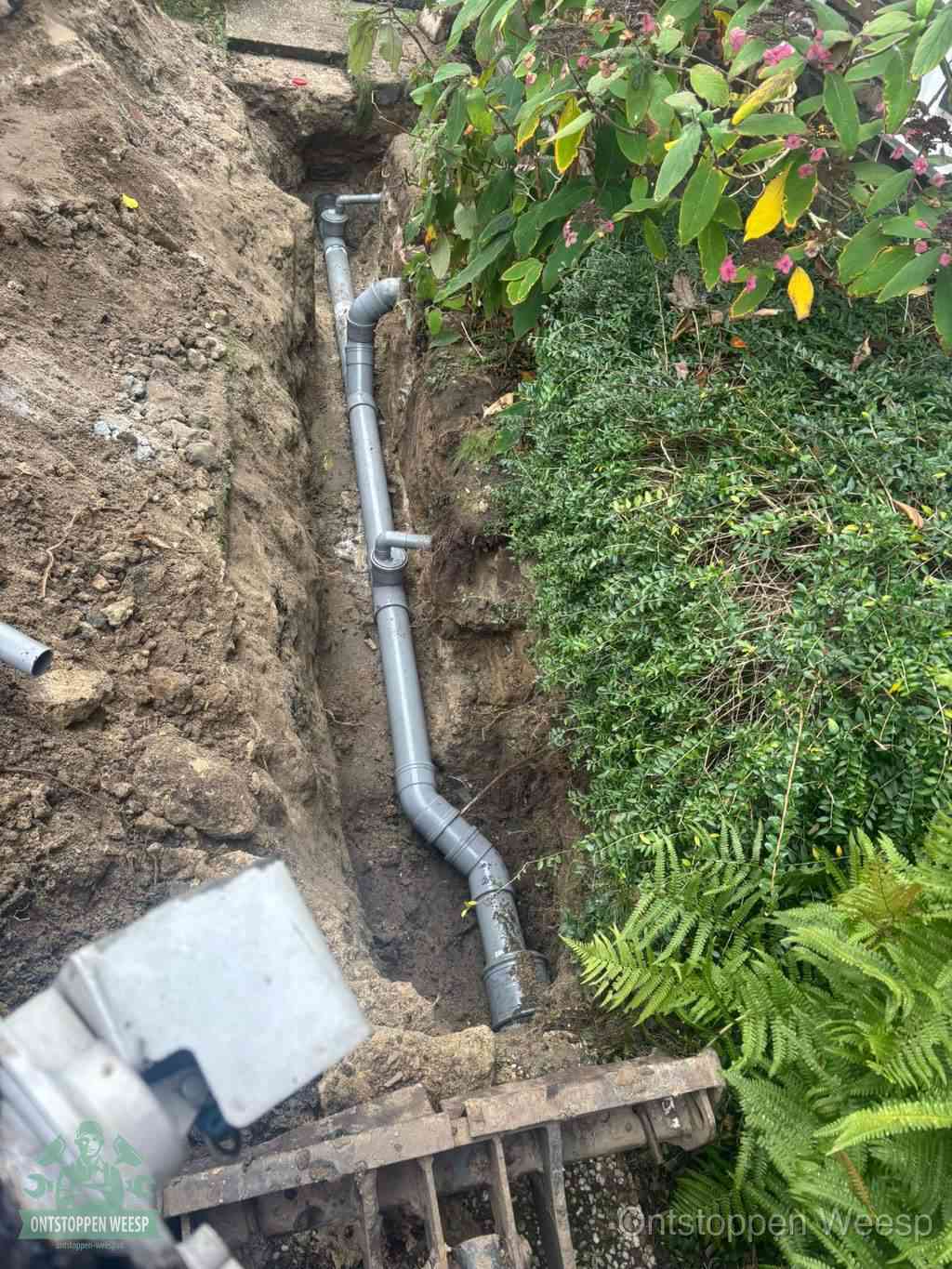 Open sleuf met nieuwe PVC-buizen, riool repareren en vervangen in Weesp