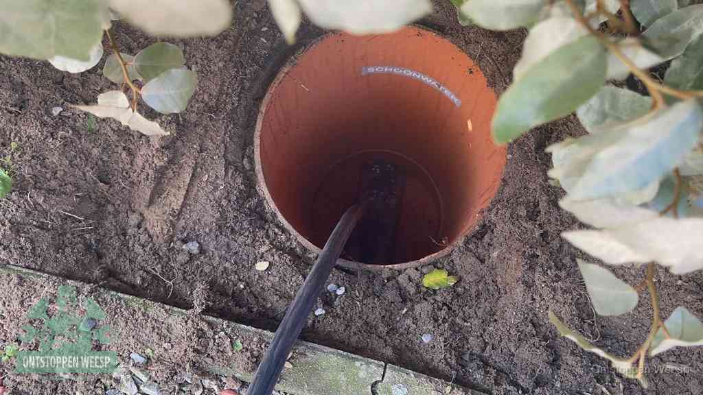 Open inspectieput in de tuin waar een veer rioolvliegjes en stankoverlast aanpakt in Weesp