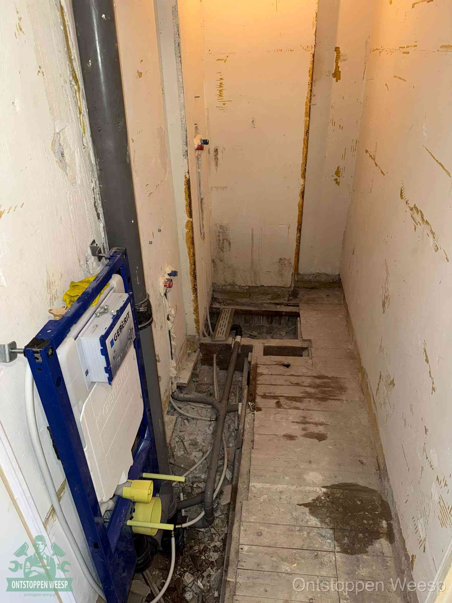 Een opgebroken toiletruimte tijdens renovatie met een Geberit inbouwreservoir en blootliggende oude afvoerleidingen, typisch voor oudere woningen in Weesp